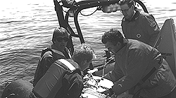 Canadian Coast Guard personnel from Westport, Nova Scotia, arrive with a motor for the disentanglement team's inflatable raft.