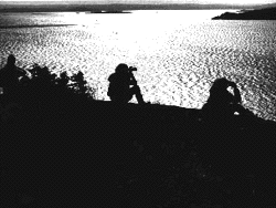 Image - Earthwatch Institute volunteers at Acadia National Park scan the water for signs of whales. Earthwatch organizes trips for travelers who want to help scientists and researchers working to study and conserve the environment.